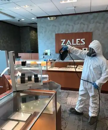 Tyvek-suited Surfco technician behind a Zales jewelry counter