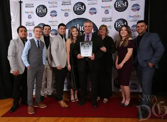 Ten Surfco staff in formal wear on the Best of Northwest Arkansas red carpet holding the award